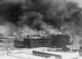 In this historical image from 1921, courtesy of the Library of Congress, smoke rises over Tulsa, Oklahoma, amid the Tulsa Race Massacre—recognized as one of the most horrific acts of violence against Black individuals in U.S. history. (Source: Alvin C. Krupnick Co./AP)