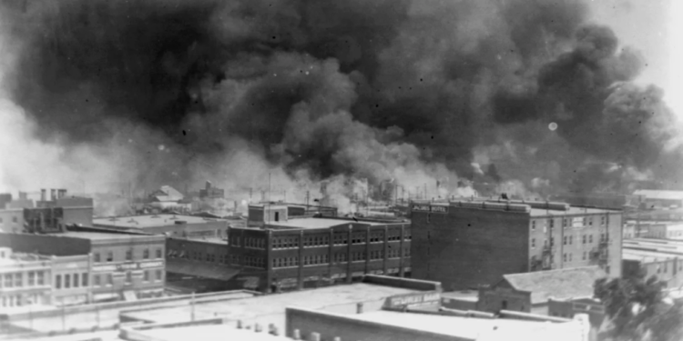 In this historical image from 1921, courtesy of the Library of Congress, smoke rises over Tulsa, Oklahoma, amid the Tulsa Race Massacre—recognized as one of the most horrific acts of violence against Black individuals in U.S. history. (Source: Alvin C. Krupnick Co./AP)