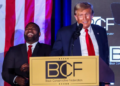 U.S. Congressman Byron Donalds chuckles while former President and Republican presidential candidate Donald Trump gives a keynote address at the Black Conservative Federation gala dinner on February 23, 2024. [Alyssa Pointer/Reuters]