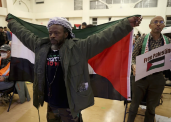 FILE - Jabari Shaw waves a Palestinian flag during an Oakland Unified School District board meeting at La Escuelita Elementary School in Oakland, California, on Wednesday, November 8, 2023. (Jane Tyska/Bay Area News Group via AP)