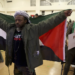 FILE - Jabari Shaw waves a Palestinian flag during an Oakland Unified School District board meeting at La Escuelita Elementary School in Oakland, California, on Wednesday, November 8, 2023. (Jane Tyska/Bay Area News Group via AP)