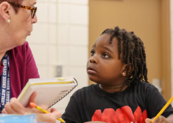 In January at Curlew Creek Elementary School, tutor Susan Cohen from the Read Across Pinellas program assists first grader Za’mir Maceachron with a reading lesson. The Pinellas County school district has launched similar initiatives aimed at closing the achievement gap among its students. [DOUGLAS R. CLIFFORD | Times]