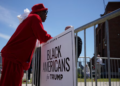 An attendee stands beside a "Black Americans for Trump" sign outside a community roundtable event featuring Republican presidential candidate and former U.S. President Donald Trump at 180 Church in Detroit, Michigan, on June 15, 2024. Photo by REUTERS/Brian Snyder. Purchase Licensing Rights.