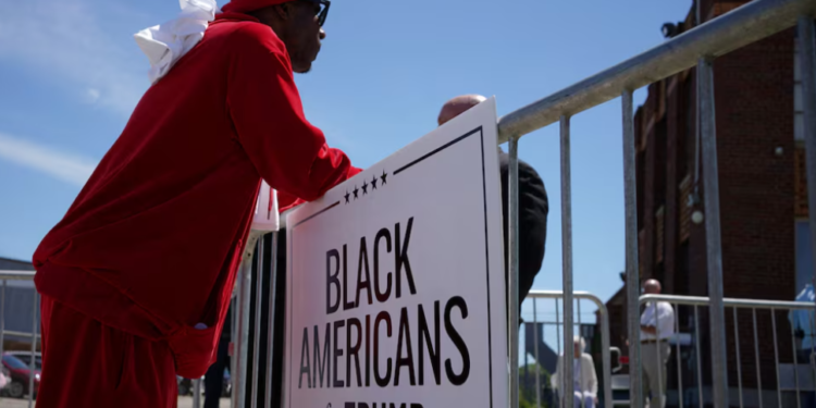 An attendee stands beside a "Black Americans for Trump" sign outside a community roundtable event featuring Republican presidential candidate and former U.S. President Donald Trump at 180 Church in Detroit, Michigan, on June 15, 2024. Photo by REUTERS/Brian Snyder. Purchase Licensing Rights.