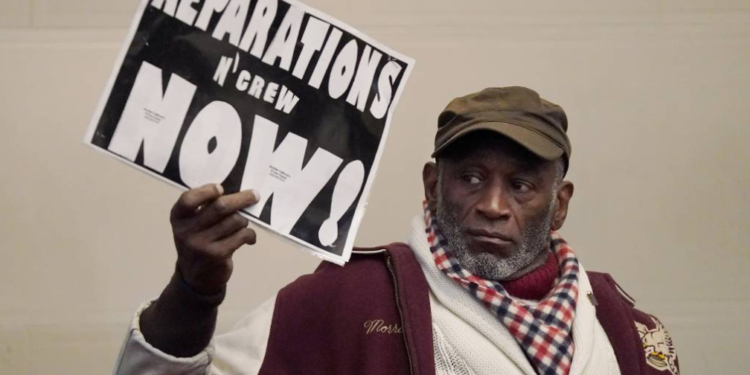 During a meeting on December 14, 2022, Morris Griffin displayed a sign while participating in the Task Force to Study and Develop Reparation Proposals for African Americans in Oakland, California. Over the past year, the Alameda County Reparations Commission has made minimal progress. Recently, the county extended the commission's mandate for another two years but allocated just $92,000—less than 2% of the total budget requested. With such limited resources, the commission is now forced to reevaluate its realistic objectives. (Jeff Chiu/AP Photo)