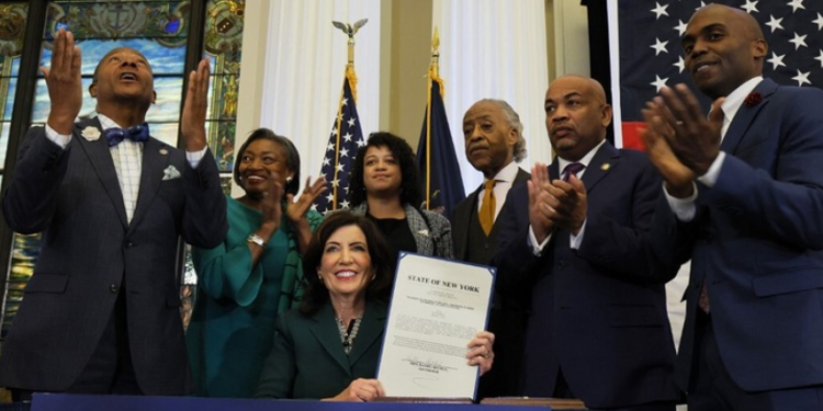 New York Governor Kathy Hochul (center) signs a bill creating the state’s reparations commission. © MICHAEL M. SANTIAGO / GETTY IMAGES NORTH AMERICA / GETTY IMAGES VIA AFP