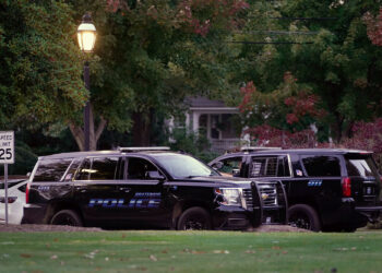 Officers converse at the entrance of the Village of Bratenahl Town Hall on October 11, 2022. (Photo by Gus Chan for The Marshall Project)