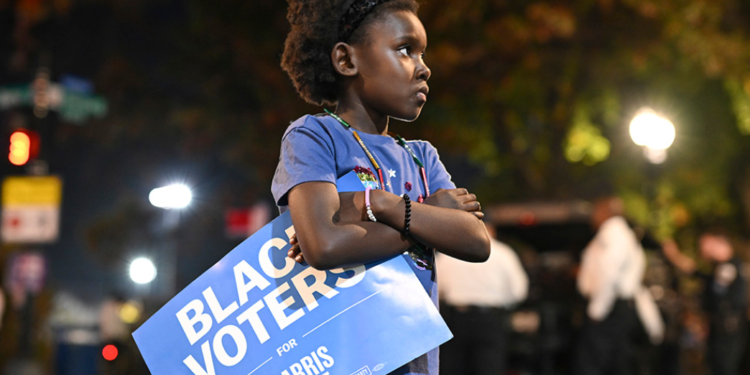A young girl proudly holds a "Black Voters for Harris-Walz" sign outside the election night watch party for Democratic presidential nominee Vice President Kamala Harris at Howard University in Washington on Tuesday, Nov. 5. (AP photo/Terrance Williams)