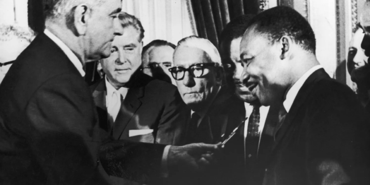 On August 6, 1965, U.S. President Lyndon B. Johnson hands a pen to Reverend Martin Luther King Jr. during the signing of the Voting Rights Act, which ruled literacy tests unconstitutional. (Washington Bureau / Getty Images)