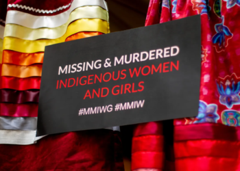 Miranda Mishan, the Portland Tribal Relations Community Liaison, created an installation featuring six red ribbon skirts displayed in the atrium of Portland City Hall. These empty skirts symbolize the alarming levels of violence experienced by Indigenous people. Photo by Jarrette Werk, Underscore News/Report for America.