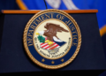 The United States Department of Justice seal is shown on a podium ahead of a news conference at the Justice Department in Washington, on Thursday, April 13, 2023. (AP Photo/Evan Vucci, File)