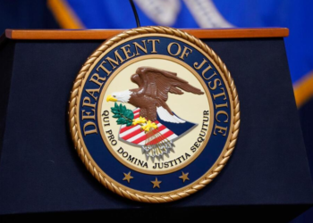 The United States Department of Justice seal is shown on a podium ahead of a news conference at the Justice Department in Washington, on Thursday, April 13, 2023. (AP Photo/Evan Vucci, File)