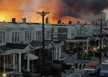 In this archival photo from May 13, 1985, flames engulf numerous row houses in West Philadelphia after police dropped a bomb on the MOVE organization's residence. (AP Photo, File)