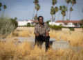 Alvin Taylor sits on the remnants of a home's foundation in Section 14, Palm Springs, where his own home was taken. (Jason Armond / Los Angeles Times)