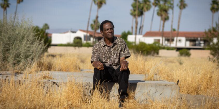 Alvin Taylor sits on the remnants of a home's foundation in Section 14, Palm Springs, where his own home was taken. (Jason Armond / Los Angeles Times)