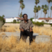 Alvin Taylor sits on the remnants of a home's foundation in Section 14, Palm Springs, where his own home was taken. (Jason Armond / Los Angeles Times)