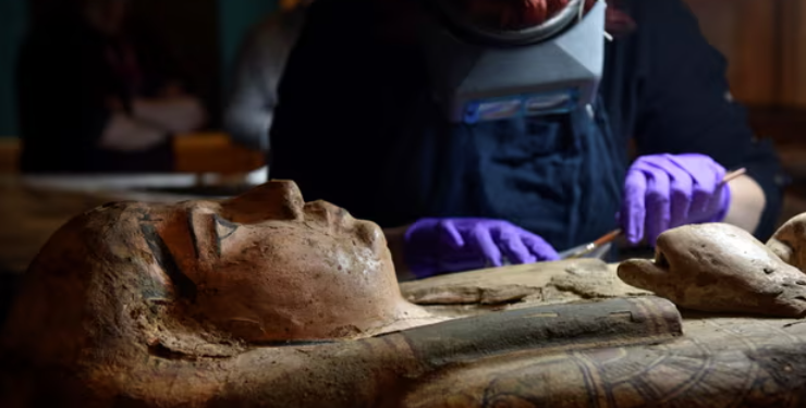 A conservator carefully cleans the 2,700-year-old sarcophagus of Ta-Kr-Hb. Photograph: Julie Howden