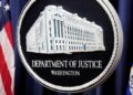 The Justice Department logo is displayed ahead of a news conference at the Department of Justice on Aug. 23, 2024, in Washington. (AP Photo/Mark Schiefelbein, File)