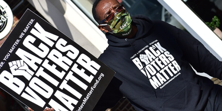 A Black voter in Graham, North Carolina, on November 3, 2020. Photo by Anthony Crider, shared under a Creative Commons license via Wikimedia Commons.