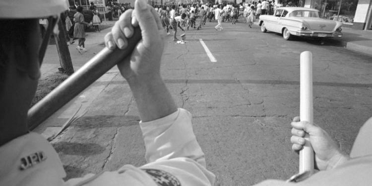 Demonstrators flee the scene as they encounter a human barricade formed by police in Jackson, Mississippi, on May 31, 1963. (AP Photo/Jim Bourdier, File)