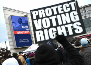 In 2022, a participant in Washington, D.C.'s annual Martin Luther King Jr. Memorial Peace Walk held a sign reading "PROTECT VOTING RIGHTS." Photo by Mandel Ngan/AFP via Getty Images.