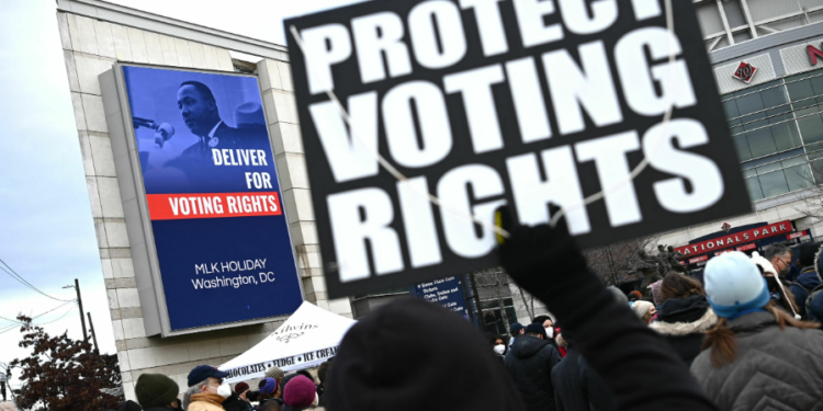 In 2022, a participant in Washington, D.C.'s annual Martin Luther King Jr. Memorial Peace Walk held a sign reading "PROTECT VOTING RIGHTS." Photo by Mandel Ngan/AFP via Getty Images.