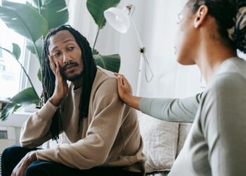 ethnic psychologist touching black depressed clients shoulder