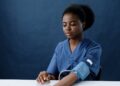 a healthcare worker measuring her own blood pressure using a sphygmomanometer
