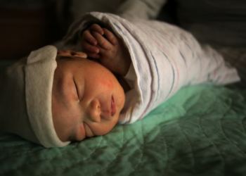 A newborn rests alongside his mother at the Lawrence General Hospital Birthing Center in 2022. (Lane Turner/Globe Staff)