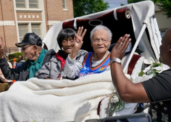 Survivors of the Tulsa Race Massacre, from left to right, Hughes Van Ellis Sr., Lessie Benningfield Randle, and Viola Fletcher, wave and high-five supporters from a horse-drawn carriage ahead of a march in Tulsa, Oklahoma, on May 28, 2021. (Photo by Sue Ogrocki / AP Photo)