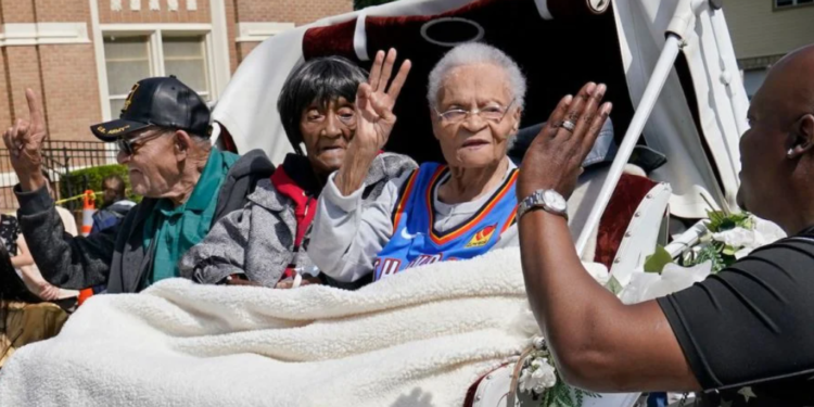 Survivors of the Tulsa Race Massacre, from left to right, Hughes Van Ellis Sr., Lessie Benningfield Randle, and Viola Fletcher, wave and high-five supporters from a horse-drawn carriage ahead of a march in Tulsa, Oklahoma, on May 28, 2021. (Photo by Sue Ogrocki / AP Photo)