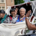 Survivors of the Tulsa Race Massacre, from left to right, Hughes Van Ellis Sr., Lessie Benningfield Randle, and Viola Fletcher, wave and high-five supporters from a horse-drawn carriage ahead of a march in Tulsa, Oklahoma, on May 28, 2021. (Photo by Sue Ogrocki / AP Photo)