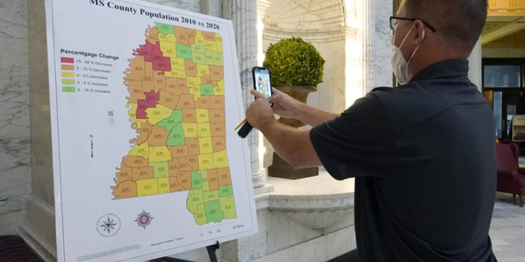 A visitor at the Mississippi Capitol in Jackson captures a photo on his cell phone of a graphic illustrating the census growth or decline across the state's counties over a 10-year span, on Thursday, Aug. 26, 2021. (AP Photo/Rogelio V. Solis)