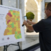 A visitor at the Mississippi Capitol in Jackson captures a photo on his cell phone of a graphic illustrating the census growth or decline across the state's counties over a 10-year span, on Thursday, Aug. 26, 2021. (AP Photo/Rogelio V. Solis)
