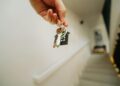 hand holding house keychain symbolizing real estate