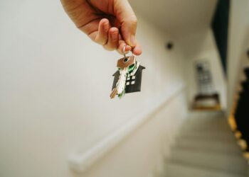 hand holding house keychain symbolizing real estate