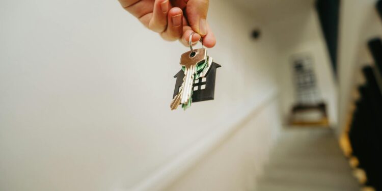 hand holding house keychain symbolizing real estate