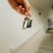 hand holding house keychain symbolizing real estate