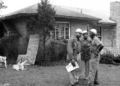 Three civil rights activists stand watch outside NAACP attorney Arthur Shores' home in September 1963, a day after it was struck by a dynamite explosion. — AP