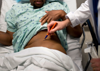 A doctor at Johns Hopkins Hospital labels the kidney to be removed from a living Black donor in this 2012 photo. Brendan Smialowski/AFP/Getty Images/File