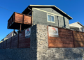 A house in South Seattle features Black Legacy Homeowners signs, with one positioned at the corner where two perpendicular gate walls meet. (Photo: Yuko Kodama)