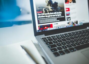 gray laptop computer near journals