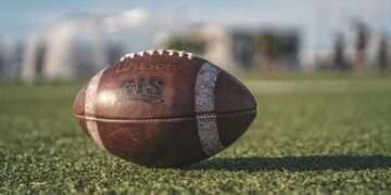 selective focus close up photo of brown wilson pigskin football on green grass