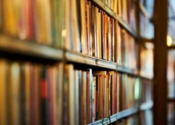 selective focus photography of brown wooden book shelf