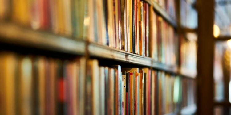 selective focus photography of brown wooden book shelf