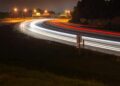 time lapse photography of fast moving cars on the road during night time