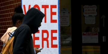 Voters at Alabama A&M University walk past a voting sign after casting their ballots at Elmore Gym on Election Day, Tuesday, Nov. 5, 2024, in Huntsville, Alabama. According to a report from the Brennan Center, the racial voting gap between white, Black, and nonwhite voters in Alabama has reached its widest point in two decades. (Eric Schultz for Alabama Reflector)