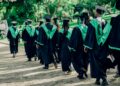 university graduates walking in outdoor ceremony