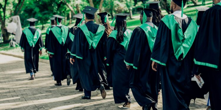 university graduates walking in outdoor ceremony