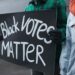 a person holding a political poster